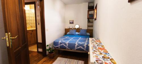 Schlafzimmer mit einem Bett mit blauer Decke in der Unterkunft Coral in Puerto