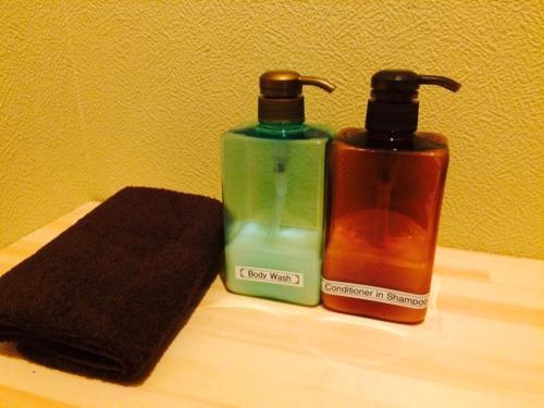 two bottles of soap sitting on a wooden shelf at ＳＡＮＡ ＩＮＮ ＴＯＷＮ - Vacation STAY 93125v in Wakayama