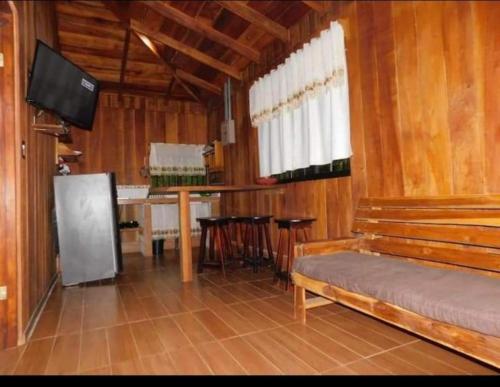 Habitación con cama, mesa y TV. en Cabañas El Okaso del Sol en Santa Cruz