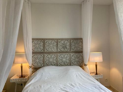 a bedroom with a white bed with two lamps at Villa climatisée calme avec piscine partagée Saint AYGULF/FREJUS in Saint-Aygulf