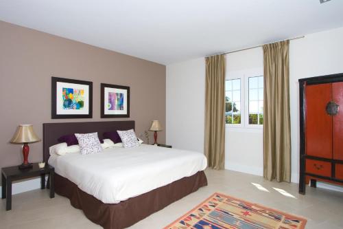 プエルト・デル・カルメンにあるVilla Perlaのベッドルーム(大型ベッド1台、大きな窓付)