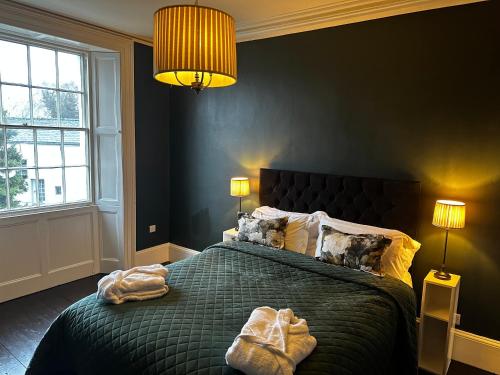 a bedroom with a green bed with two lamps at Penthouse apartment in Cockermouth