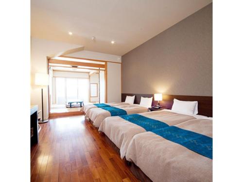 a row of four beds in a room with at Hotel Hamahigashima Resort - Vacation STAY 10606v in Uruma