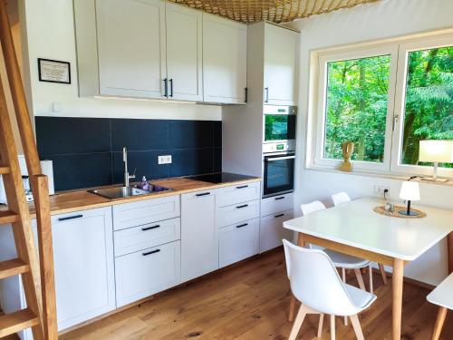 a kitchen with white cabinets and a table and chairs at Regenbogen Bad Gandersheim in Bad Gandersheim