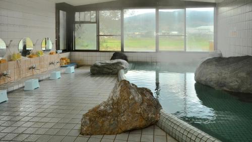 a bathroom with a rock in a pool of water at Chikugogawa Onsen Kuwanoya - Vacation STAY 44682v in Ukiha