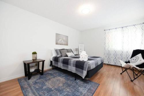 a bedroom with a bed and a table and a chair at Spacious 1BR with Parking and WiFi Near NLRHC in Fort McMurray