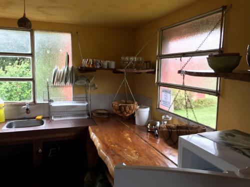 een keuken met een houten aanrecht en 2 ramen bij El Refugio en la Quebrada in Treinta y Tres