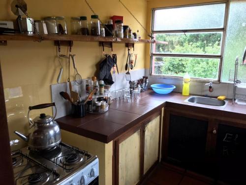 una cucina con piano cottura, lavandino e finestra di El Refugio en la Quebrada a Treinta y Tres