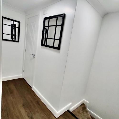a hallway with white walls and black windows at Studio 22 Lower Road Beeston in Nottingham