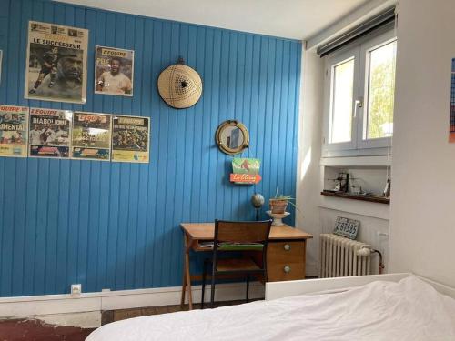 - une chambre avec un mur bleu, un bureau et un lit dans l'établissement Très calme à côté du château, à Versailles