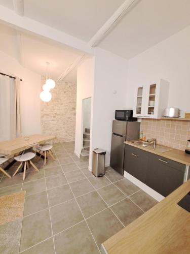 une cuisine et une salle à manger avec une table et une salle à manger dans l'établissement Appartement lumineux , Carpentras centre, à Carpentras