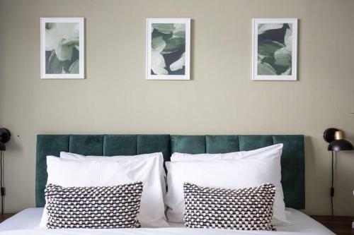 a bed with white pillows and three pictures on the wall at Mulberry View by Sorted Stay in Southend-on-Sea