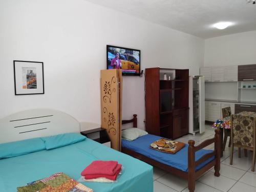 une chambre avec deux lits et une télévision au mur dans l'établissement Seu Apto Praia da Costa 3 Não divide Completo Ar Cond Fogão Geladeira Internet Local Excelente Centro Sem escadas, à Vila Velha