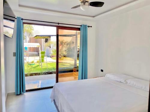 um quarto com uma cama e uma porta de vidro deslizante em Hotel Palmar Del Río em Pedernales