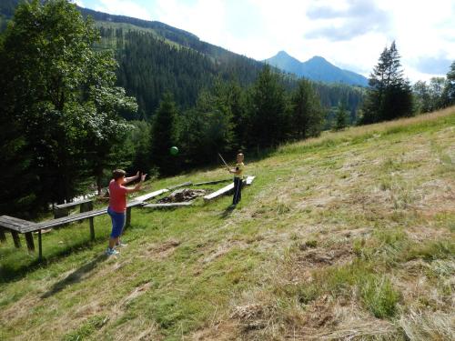 two people playing with a frisbee in a field at Goralturist in Ždiar