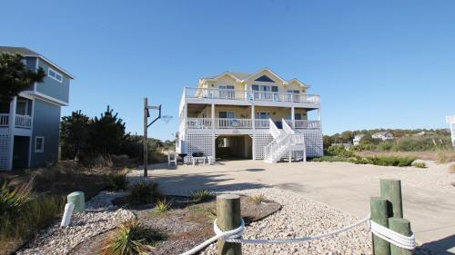 a large house on the beach with a fence at Oceanside, 7 BRs, Priv Pool, H Tub, Community Amenities, VOH3, Safe Harbor in Corolla