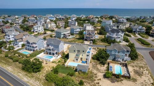 an aerial view of a neighborhood with houses and the ocean at Oceanside, 7 BRs, Priv Pool, H Tub, Community Amenities, VOH3, Safe Harbor in Corolla