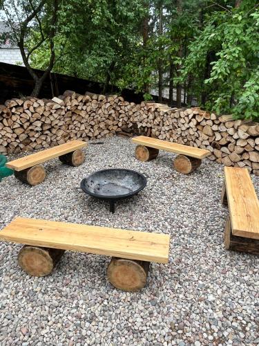 a group of benches and a fire pit in a yard at Modern Village in Nowinka