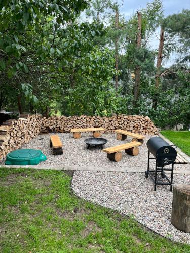 a backyard with a picnic table and benches and a grill at Modern Village in Nowinka