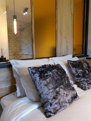 a bed with two pillows on top of it at Q-time Barvaux, Durbuy-Adults Only in Durbuy