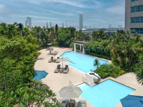 una vista aérea de una piscina con sillas y sombrillas en Holiday Inn Manila Galleria, an IHG Hotel, en Manila