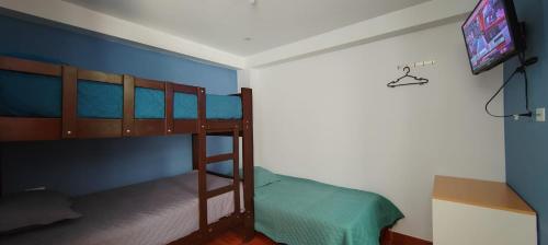 a bedroom with two bunk beds and a tv at Hostal Bryan in Tacna