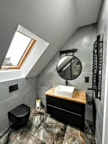 a bathroom with a sink and a mirror at Modern Village in Nowinka