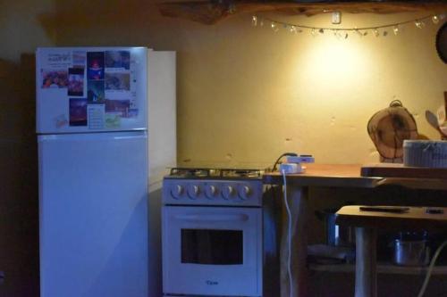 a kitchen with a stove and a white refrigerator at El Albergue del Paso Polo (Quebrada de los Cuervos) in Isla Patrulla