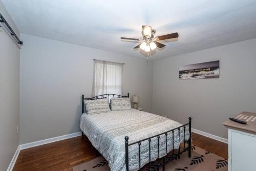 a bedroom with a bed with a ceiling fan at 3 Minute Drive to the Airport in Maryville