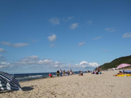 a group of people walking on the beach at Cozy holiday home 600m from the lake in Kolczewo in Kołczewo