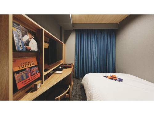松山市にあるdogo hakuro - Vacation STAY 79568vのベッドとテレビが備わるホテルルームです。