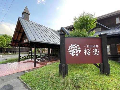 a sign in the grass in front of a building at Towadakohan Sakura - Vacation STAY 03811v in Towada