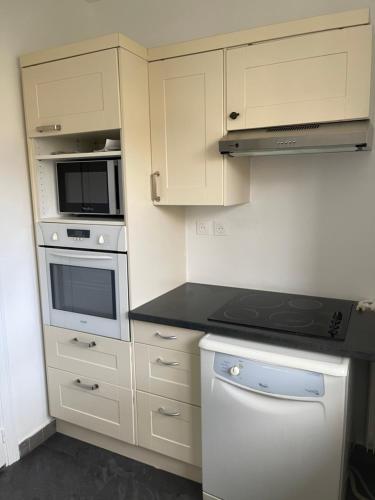een keuken met witte kasten en een fornuis met oven bij Appartement neuf à boulogne à 3 mins à pieds du métro in Boulogne-Billancourt