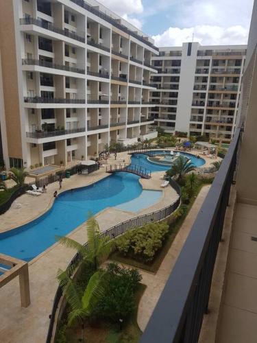 a view of a large building with two swimming pools at Apart hotel Tagualife in Riacho Fundo