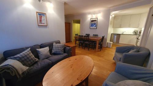 ein Wohnzimmer mit einem Sofa und einem Tisch in der Unterkunft Solli Apartments - koselig leilighet med 3 soverom in Geilo
