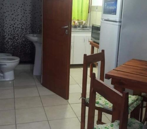 a kitchen with a table and a refrigerator and a table and chair at Cabaña 3 in Bialet Massé