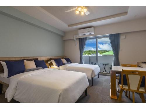 a hotel room with two beds and a balcony at Yenns Marina Inn Mashiki Condo Hotels - Vacation STAY 85633v in Ginowan