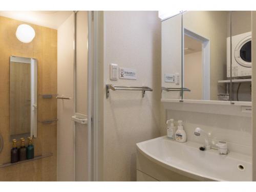 y baño con lavabo y espejo. en Yenns Marina Inn Mashiki Condo Hotels - Vacation STAY 85633v en Ginowan