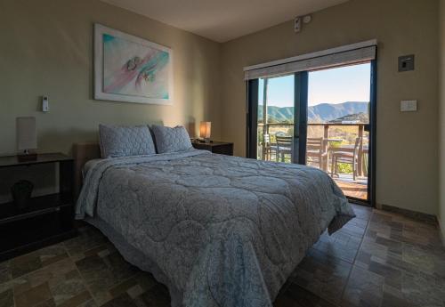 a bedroom with a bed and a balcony with a view at Finca de Lulu y Jose Ruta del Vino in Valle de Guadalupe