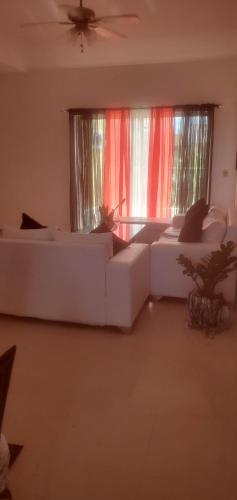 a living room with two white couches in front of windows at room in 2bedroom apartment, white Sands, Bavaro in Punta Cana