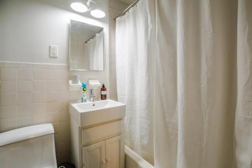 uma casa de banho com uma cortina de chuveiro branca e um lavatório. em Apartment 224: Upper West Side em Nova York