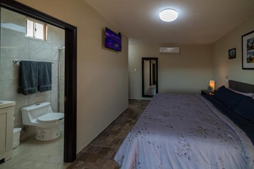 1 dormitorio con cama, ducha y aseo en Finca de Lulu y Jose Ruta del Vino, en Valle de Guadalupe