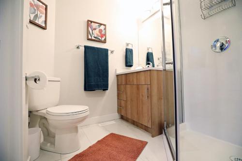 a bathroom with a toilet and a glass shower at Central 3 Queen Beds, AC, Double Garage, Disney in Edmonton