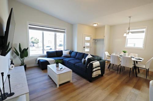 a living room with a couch and a table at Central 3 Queen Beds, AC, Double Garage, Disney in Edmonton