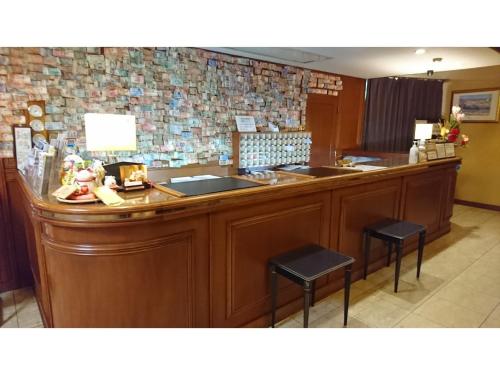 una cucina con bancone, 2 sgabelli e piano di lavoro di HOTEL SEAGULL - Vacation STAY 86778v a Izumisano