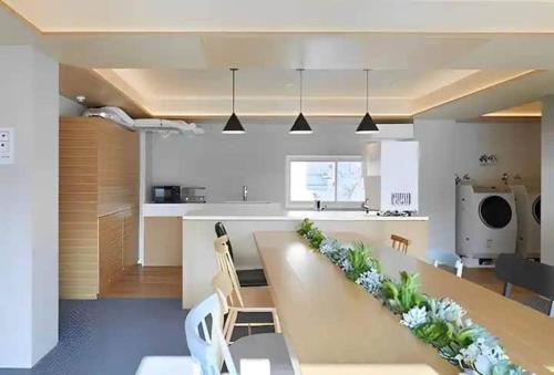 uma cozinha e sala de jantar com uma mesa longa com plantas em Kimura Building - Vacation STAY 15559 em Sapporo