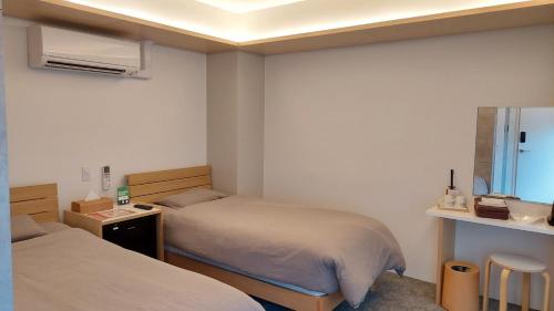 um pequeno quarto com 2 camas e um espelho em Kimura Building - Vacation STAY 15559 em Sapporo