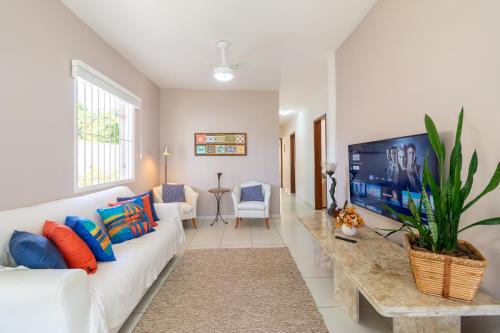安格拉杜斯雷斯Casa em Angra com Piscina e Descida para Jet Ski的客厅里有一张白色沙发和一台电视