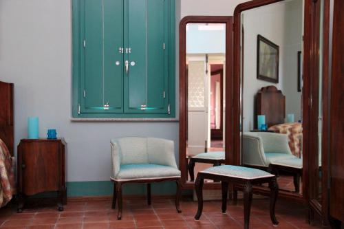 a room with green cabinets and chairs and a mirror at Agriturismo Petrara in Simeri