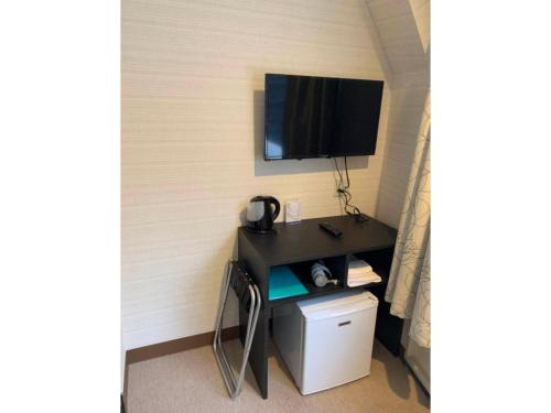 a room with a desk with a tv on a wall at Tabata Oji Hotel - Vacation STAY 89847v in Tokyo